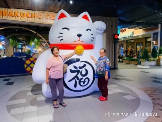 Dynamic Kung Fu Demo by Two Women at Cheerful Cat Statue – AI Generated Video | Hailuo AI