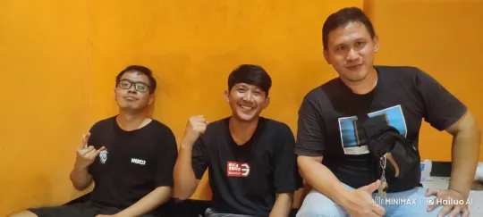 Three Men Display Camaraderie Against Orange Wall – AI Generated Video | Hailuo AI