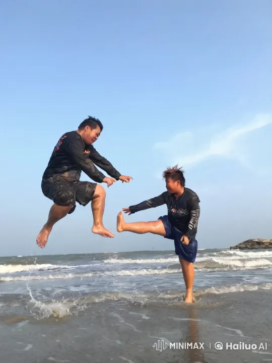 Beach Playfulness: Two Men Engage in Dynamic Jumping Game – AI Generated Video | Hailuo AI