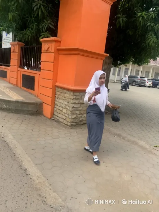 Young Woman Walking with Phone and Bag Near School – AI Generated Video | Hailuo AI