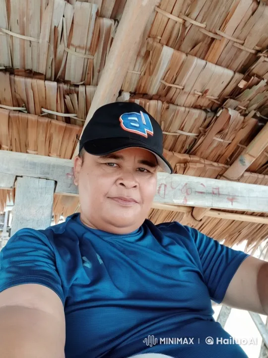Person Relaxing Under Thatched Roof with Wood Beams – AI Generated Video | Hailuo AI