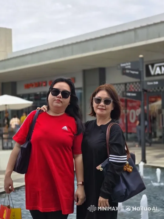 Two Friends Enjoy Shopping with Dynamic Fountain – AI Generated Video | Hailuo AI