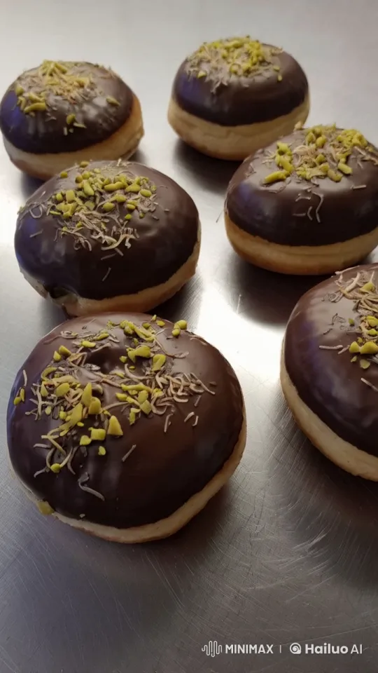 Close-Up of Chocolate Doughnuts with Nuts and Coconut – AI Generated Video | Hailuo AI