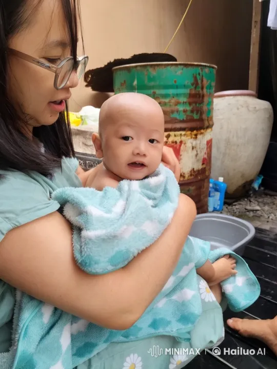 Woman in Green Dress Comforts Baby in Outdoor Setting – AI Generated Video | Hailuo AI