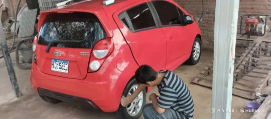 Young Man Cleans Chevrolet Spark's Wheel in Garage – AI Generated Video | Hailuo AI