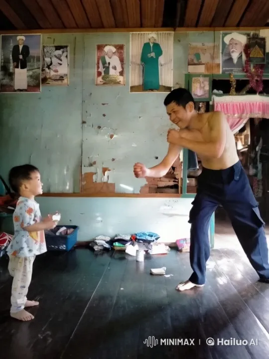 Rustic Interior: Shirtless Man Demonstrates Kungfu to Child – AI Generated Video | Hailuo AI