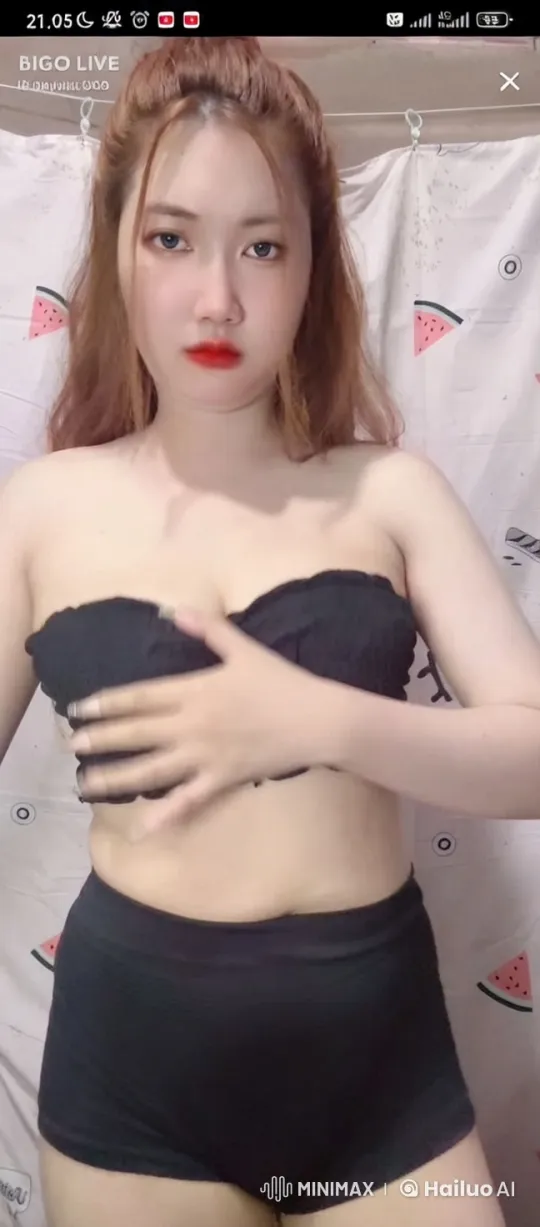 Woman Adjusts Breasts with Blindfold in Soft-Lit Setting – AI Generated Video | Hailuo AI