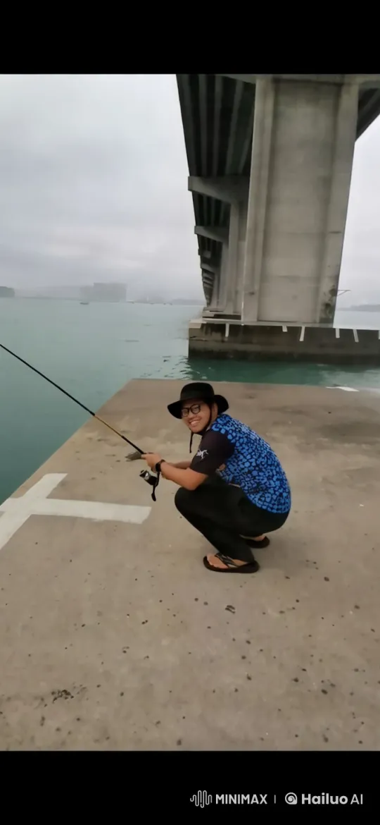 Person jumps into water while fishing on concrete platform – AI Generated Video | Hailuo AI