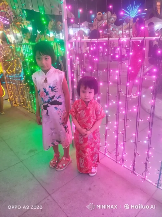 Asian Children in Traditional Attire at Lively Night Market – AI Generated Video | Hailuo AI