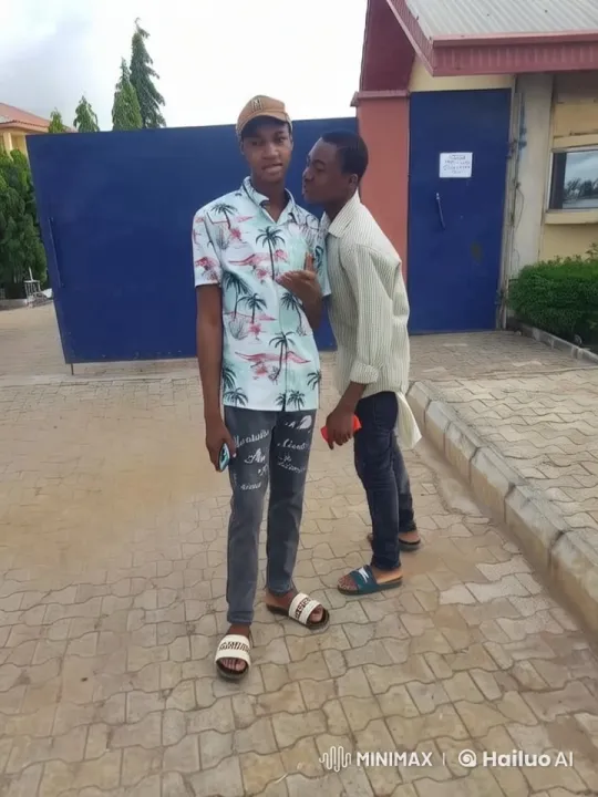 Two Young Men Chatting Outdoors Near a Building – AI Generated Video | Hailuo AI