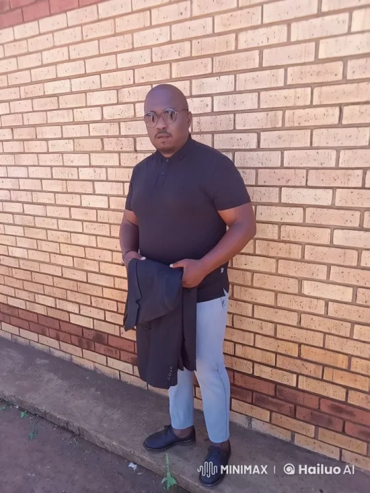 Man Adjusting Jacket Against Brick Wall in Live2D Animation – AI Generated Video | Hailuo AI