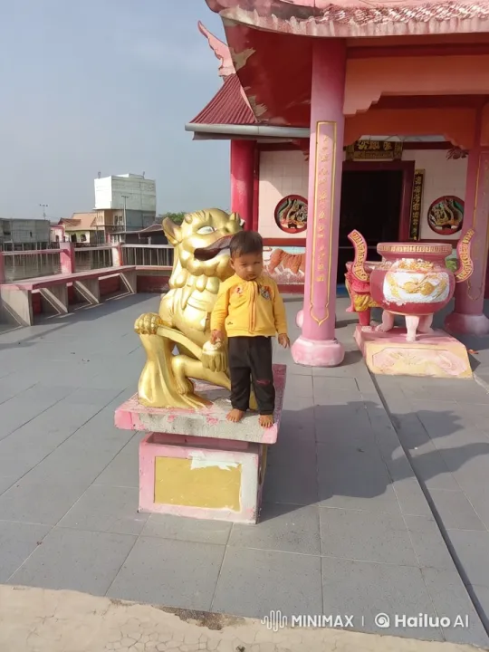 Child Practicing Kung Fu by Temple's Golden Lion Statue – AI Generated Video | Hailuo AI