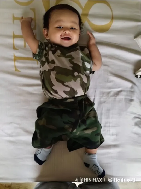 Dancing Baby in Camouflage Outfit on Bed – AI Generated Video | Hailuo AI