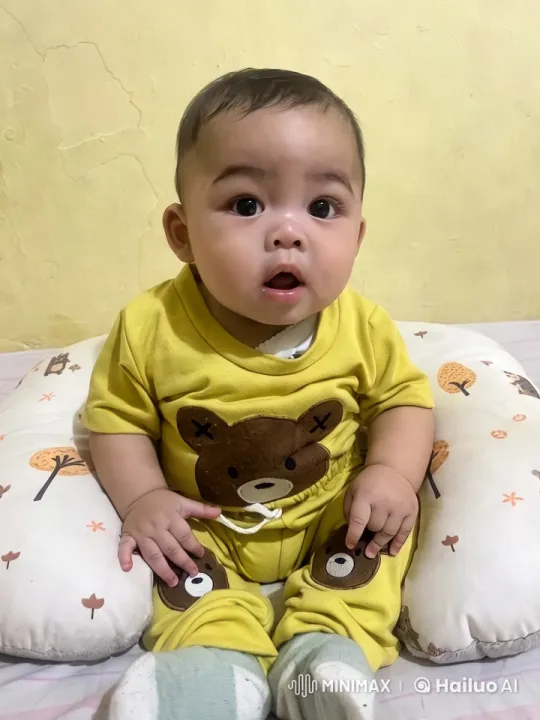 Baby in Yellow Bear Outfit on Cozy Surface – AI Generated Video | Hailuo AI