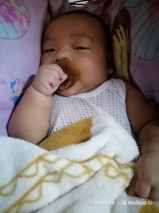 Baby in Soft Blanket Amidst Colorful Background – AI Generated Video | Hailuo AI
