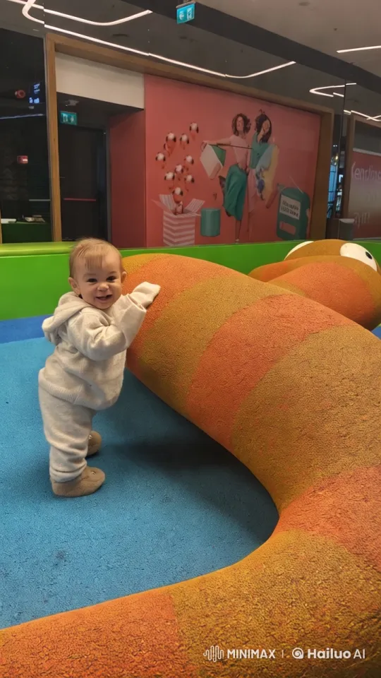 Toddler Explores Colorful Play Structure in Bright Setting – AI Generated Video | Hailuo AI