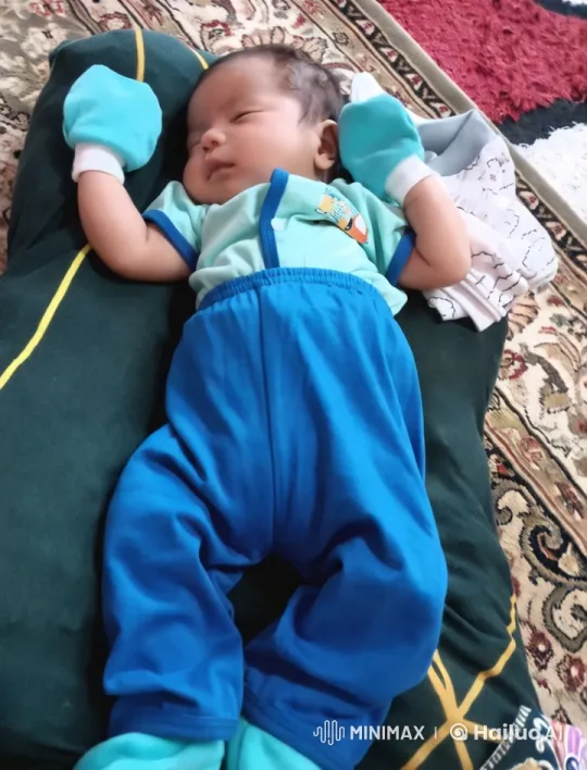 Baby in Blue Outfit on Green Cushion – AI Generated Video | Hailuo AI