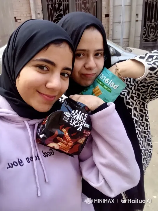 Two Women in Hijabs Enjoying Snacks in Urban Setting – AI Generated Video | Hailuo AI