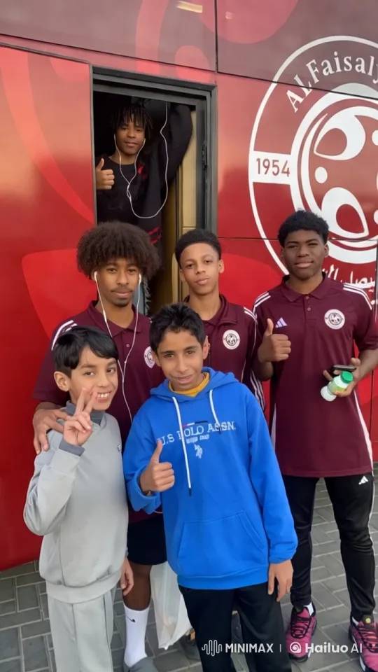 Young Athletes Pose Cheerfully in Front of Al Faisaly Club Bus – AI Generated Video | Hailuo AI