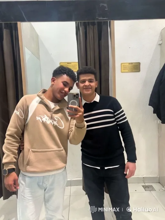 Two Men Capturing a Stylish Selfie in a Modern Dressing Room – AI Generated Video | Hailuo AI