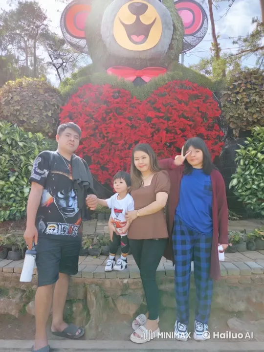 Family Mimics Kungfu in Front of Flower Bear Display – AI Generated Video | Hailuo AI