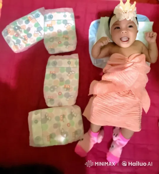 Baby with Diapers Arranged as '1' on Red Quilt – AI Generated Video | Hailuo AI