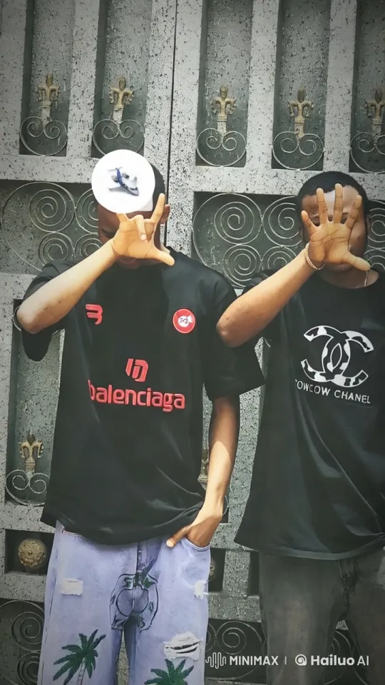 Fashionable Duo Showcases Style in Front of Ornate Gate – AI Generated Video | Hailuo AI