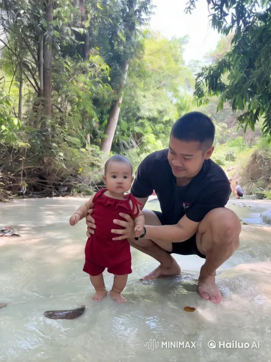 Man and Baby Enjoy Tranquil Moment in Forest Stream – AI Generated Video | Hailuo AI