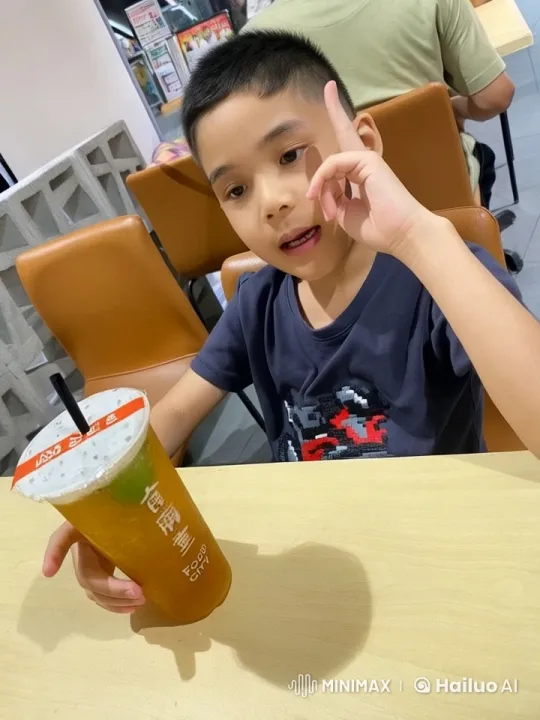 Young Boy Enjoying Iced Tea in Casual Dining Setting – AI Generated Video | Hailuo AI