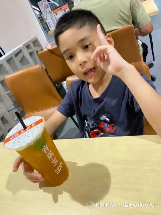 Child Enjoying Iced Tea in Modern Café – AI Generated Video | Hailuo AI