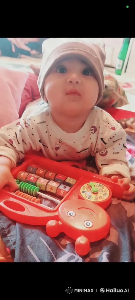 Baby Engages with Educational Toy on Colorful Bedspread – AI Generated Video | Hailuo AI