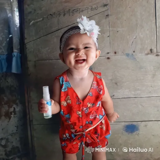 Child in Red Outfit with Spray Bottle Against Rustic Wall – AI Generated Video | Hailuo AI