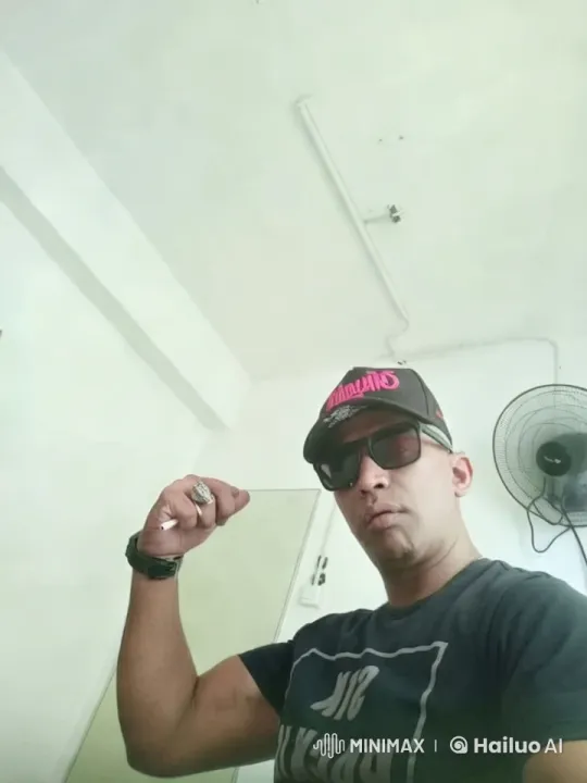 Confident Man Showcases Arm Muscles in Minimalist Room – AI Generated Video | Hailuo AI