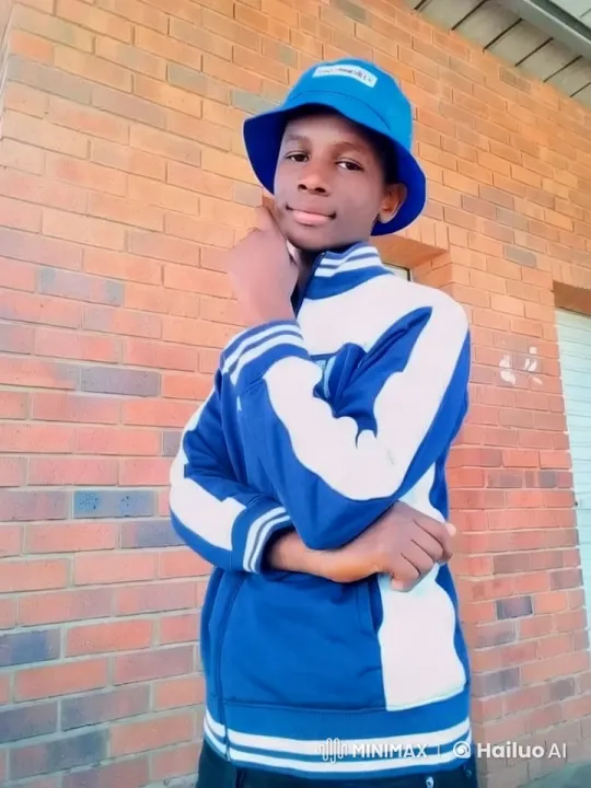 Young Man in Blue Jacket Against Brick Wall – AI Generated Video | Hailuo AI