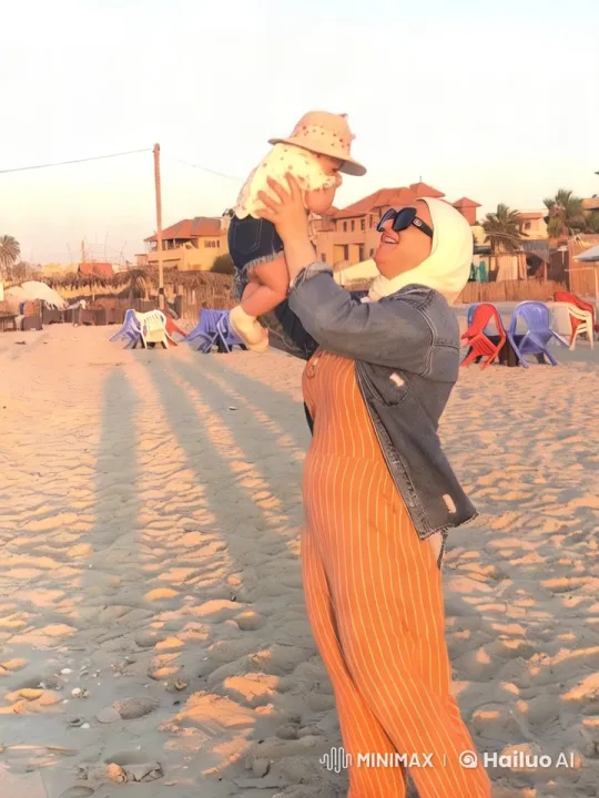 Woman Lifts Baby in Joy on Sandy Beach at Twilight – AI Generated Video | Hailuo AI
