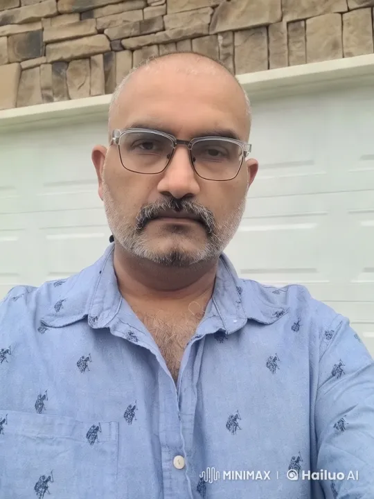 Man in Blue Shirt Stands Before a Garage Door – AI Generated Video | Hailuo AI
