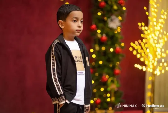 Young Boy in Burberry Amidst Festive Decor – AI Generated Video | Hailuo AI