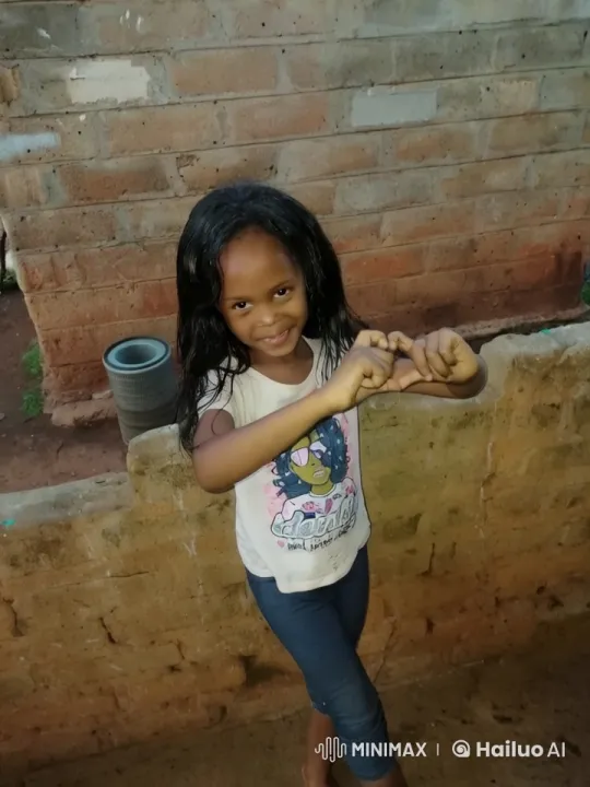 Young Girl Dancing Playfully Against Rustic Wall – AI Generated Video | Hailuo AI