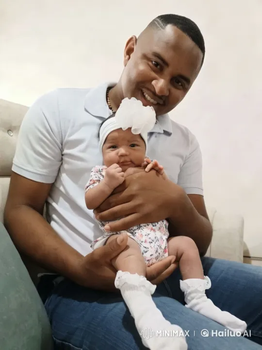 Man Stands Up Holding Baby on Couch – AI Generated Video | Hailuo AI