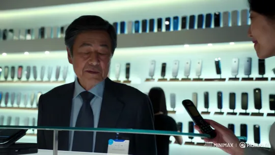Korean Man Contemplates Flip Phone in Modern Store – AI Generated Video | Hailuo AI