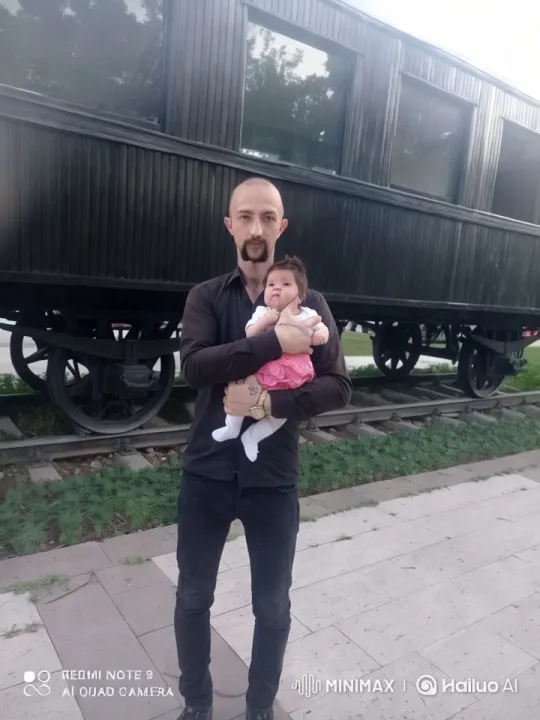 Man and Baby Embrace Before Old Train Carriage – AI Generated Video | Hailuo AI