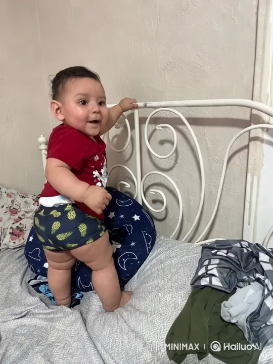 Baby Stands Playfully on Bed with Festive Outfit – AI Generated Video | Hailuo AI