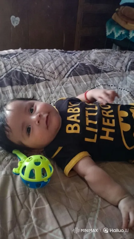 Baby in Hero Outfit with Toy Rattle on Bed – AI Generated Video | Hailuo AI