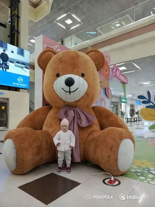 Child and Giant Teddy Bear in Colorful Mall Setting – AI Generated Video | Hailuo AI