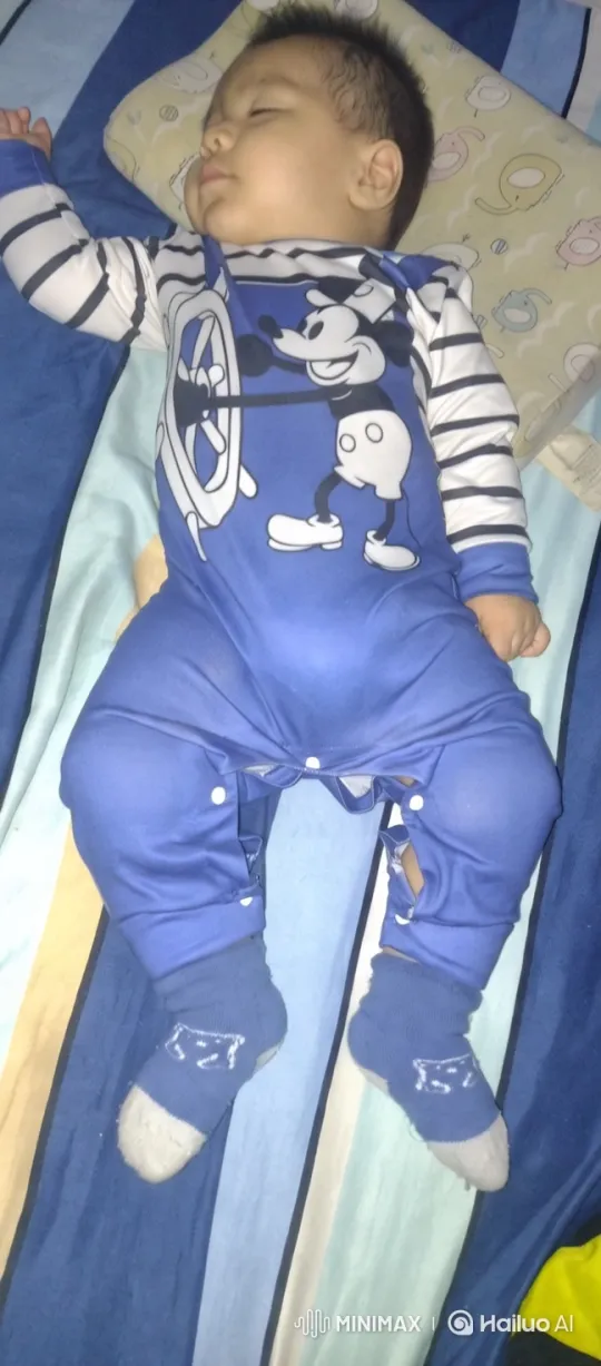 Baby in Mickey Onesie on Cozy Blue Bed – AI Generated Video | Hailuo AI