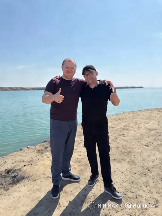 Two Men Embrace on Sandy Shoreline with Serene Water – AI Generated Video | Hailuo AI