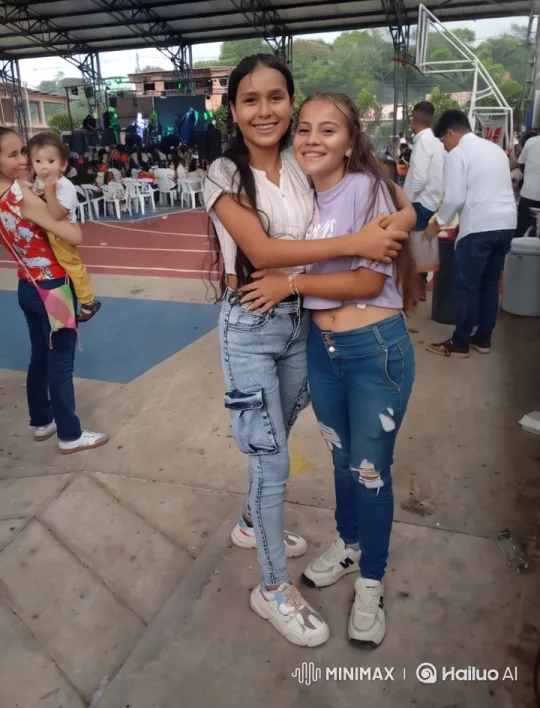 Joyful Embrace of Two Young Women at a Lively Event – AI Generated Video | Hailuo AI
