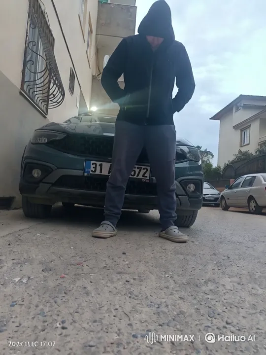 Urban Reveal: Person in Hoodie Amidst Cityscape – AI Generated Video | Hailuo AI