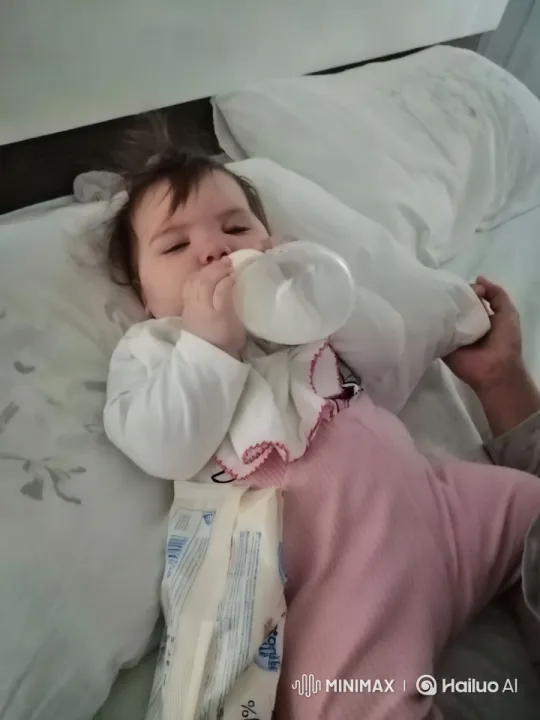 Baby Drinking Bottle Amidst Cozy Bedding Scene – AI Generated Video | Hailuo AI