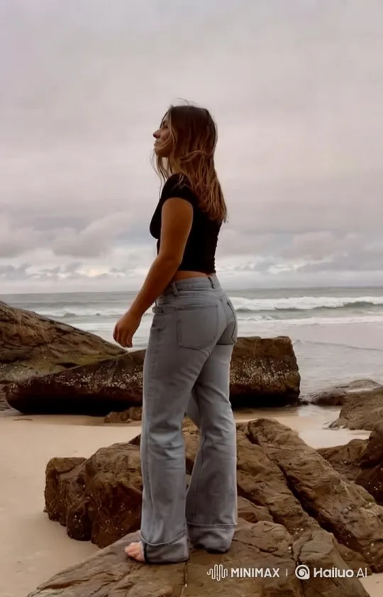 Woman on Rocky Shoreline with Flowing Hair – AI Generated Video | Hailuo AI